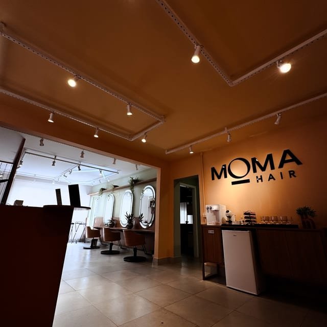 Interior do salão Moma Hair com o letreiro da marca